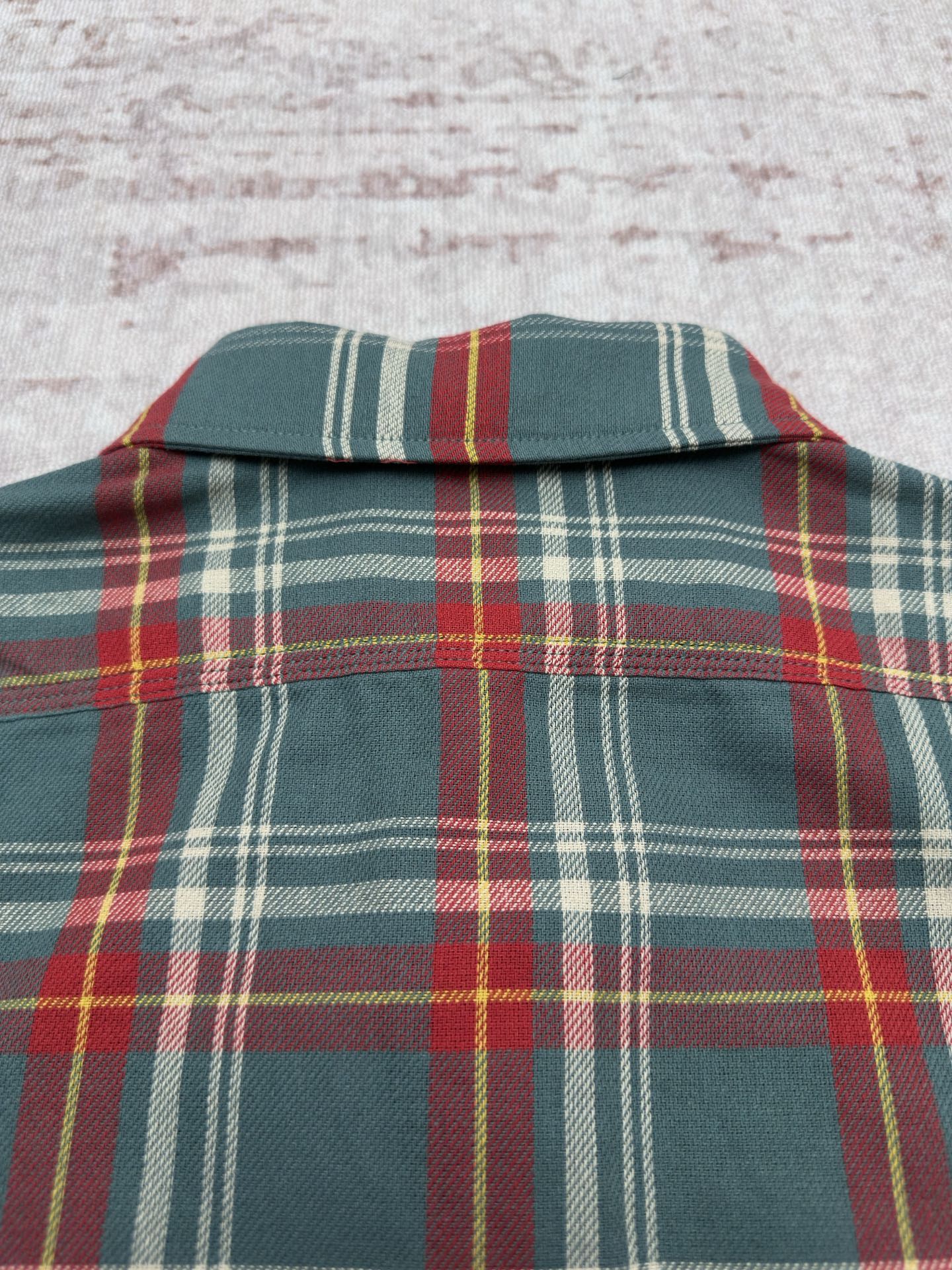 Plaid shirt yoke and upper back in teal with red, yellow, and white stripe pattern