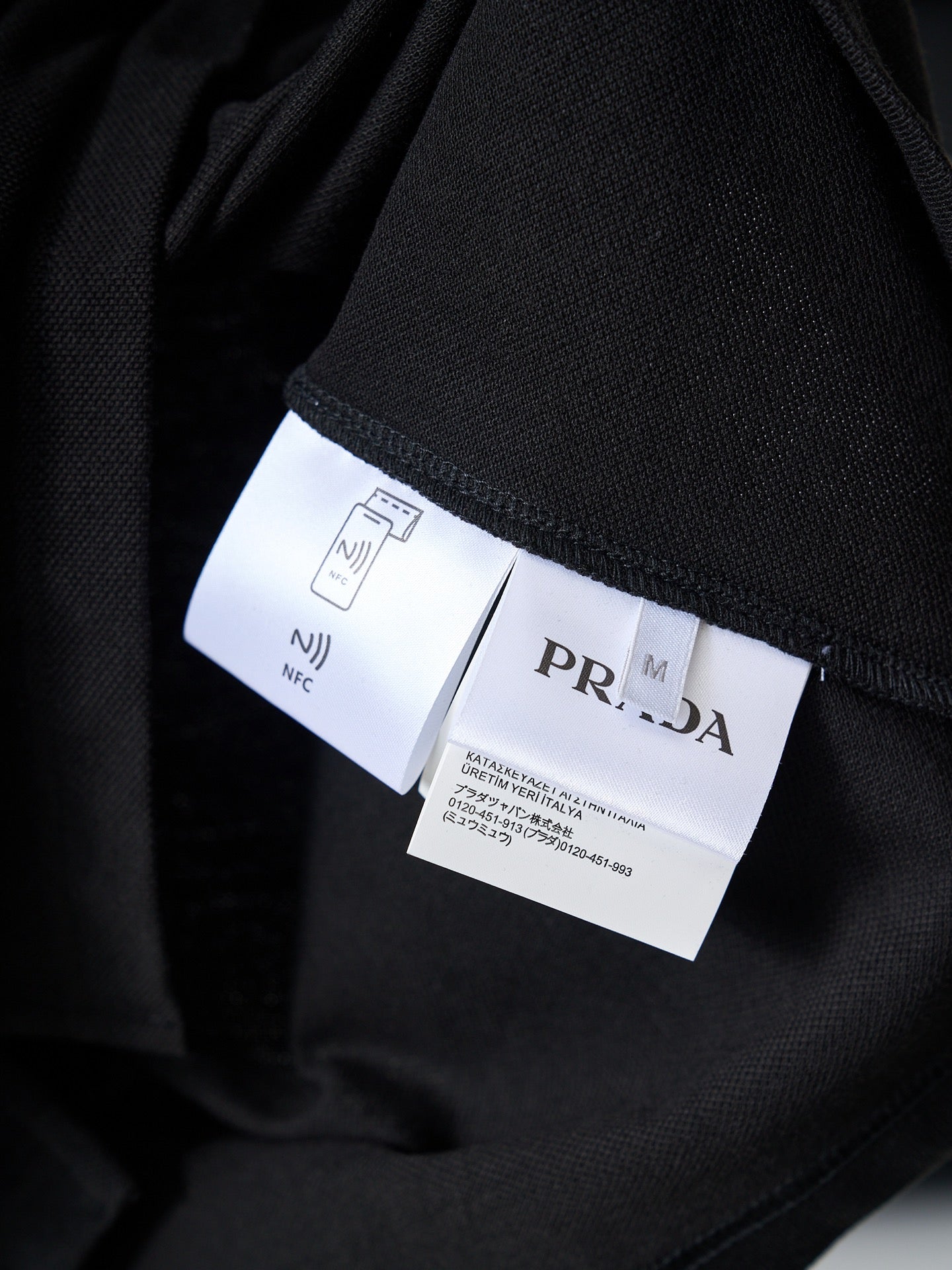 Prada polo interior label and care tags on black fabric