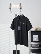 Black Prada polo shirt with triangle logo and hang tag on hanger