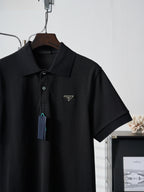 Black Prada polo shirt front view with hang tag on wooden hanger