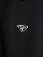 Triangle Prada logo patch on dark polo fabric
