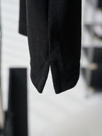 Close-up of black polo shirt hem and side seam