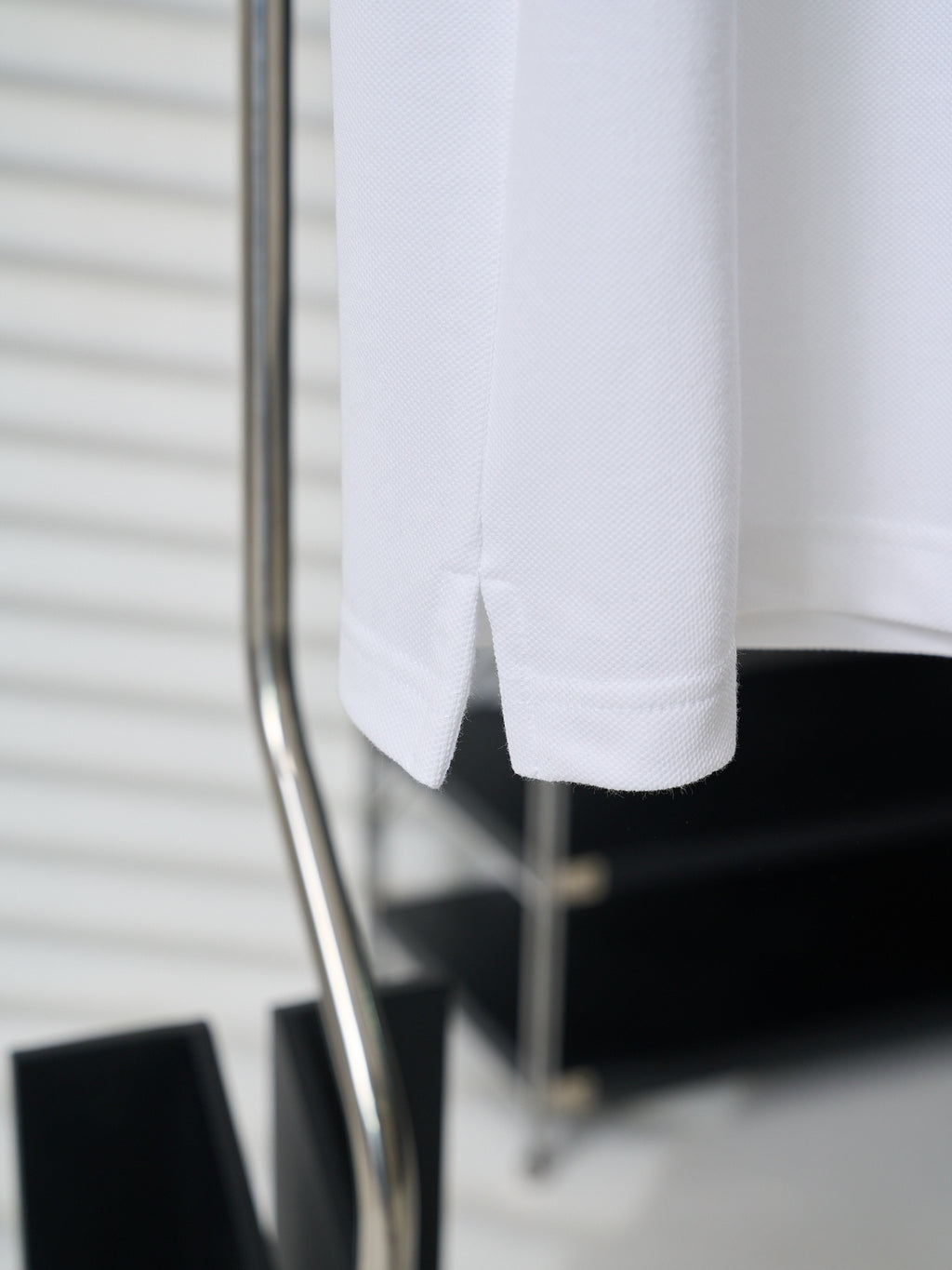White polo shirt hem and short sleeves on display stand
