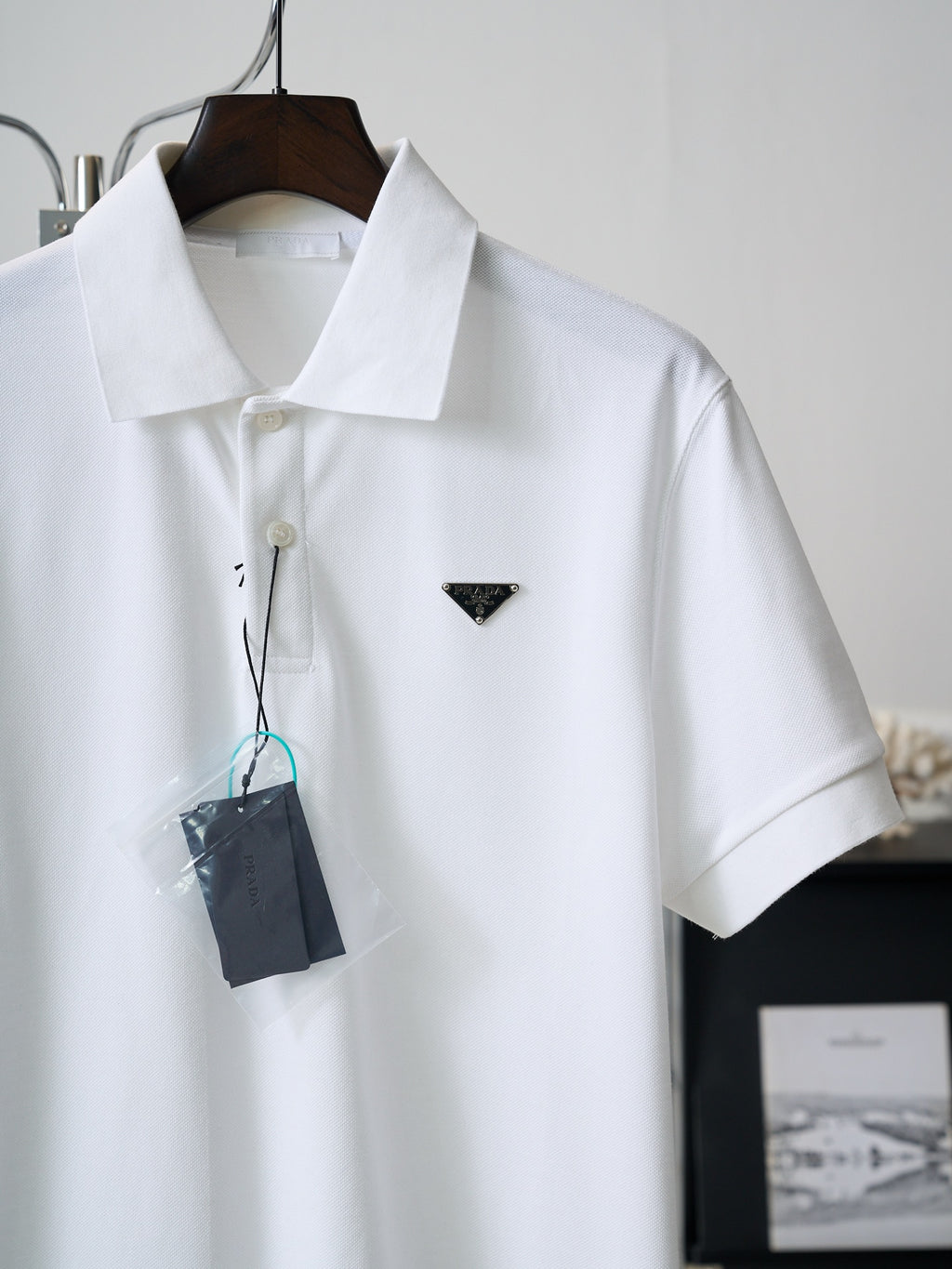 White short-sleeve polo shirt with triangle PRADA logo and hanging tag