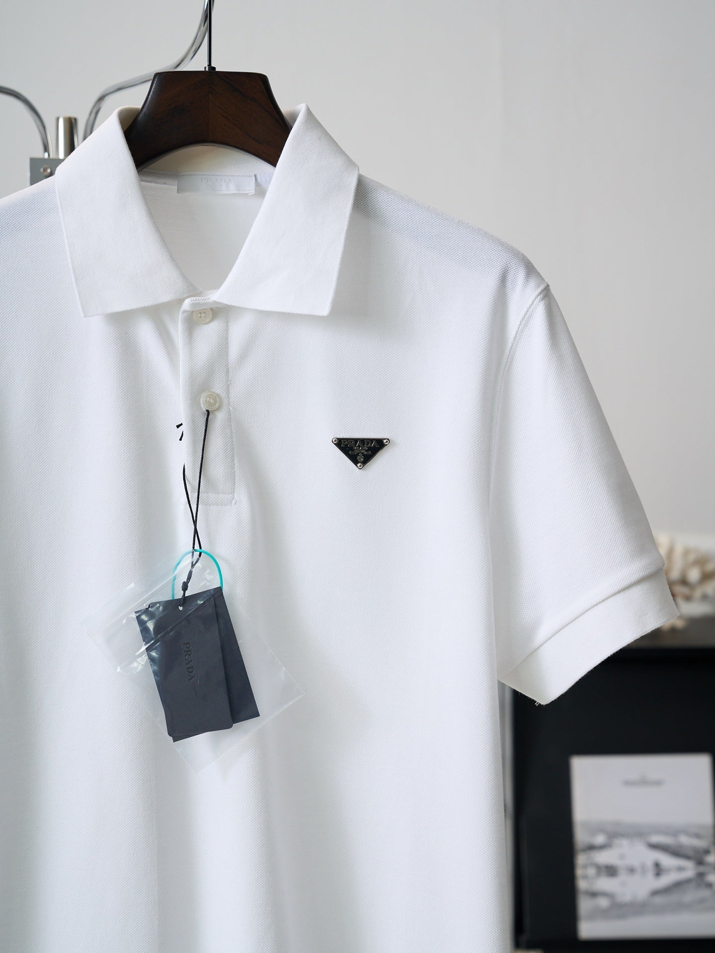 White short-sleeve polo shirt with triangle PRADA logo and hanging tag
