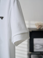 White polo shirt sleeve with embroidered PRADA logo, side view