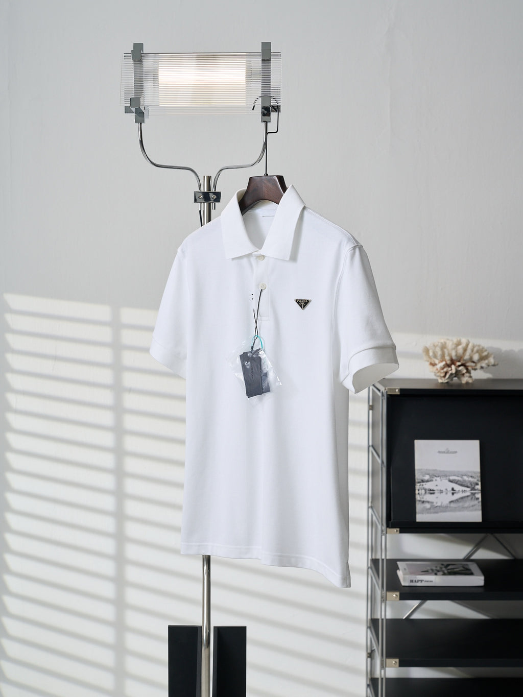 White short-sleeve polo shirt with collar and PRADA logo patch, front view