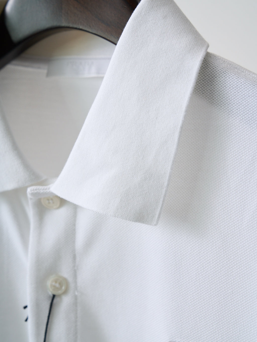 White polo shirt collar and sleeve cuff with button detail