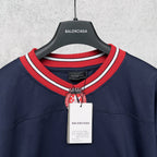 Balenciaga navy sweatshirt neckline with red-and-white striped collar and crest emblem