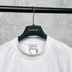 White T-shirt collar with attached hang tag on black hanger