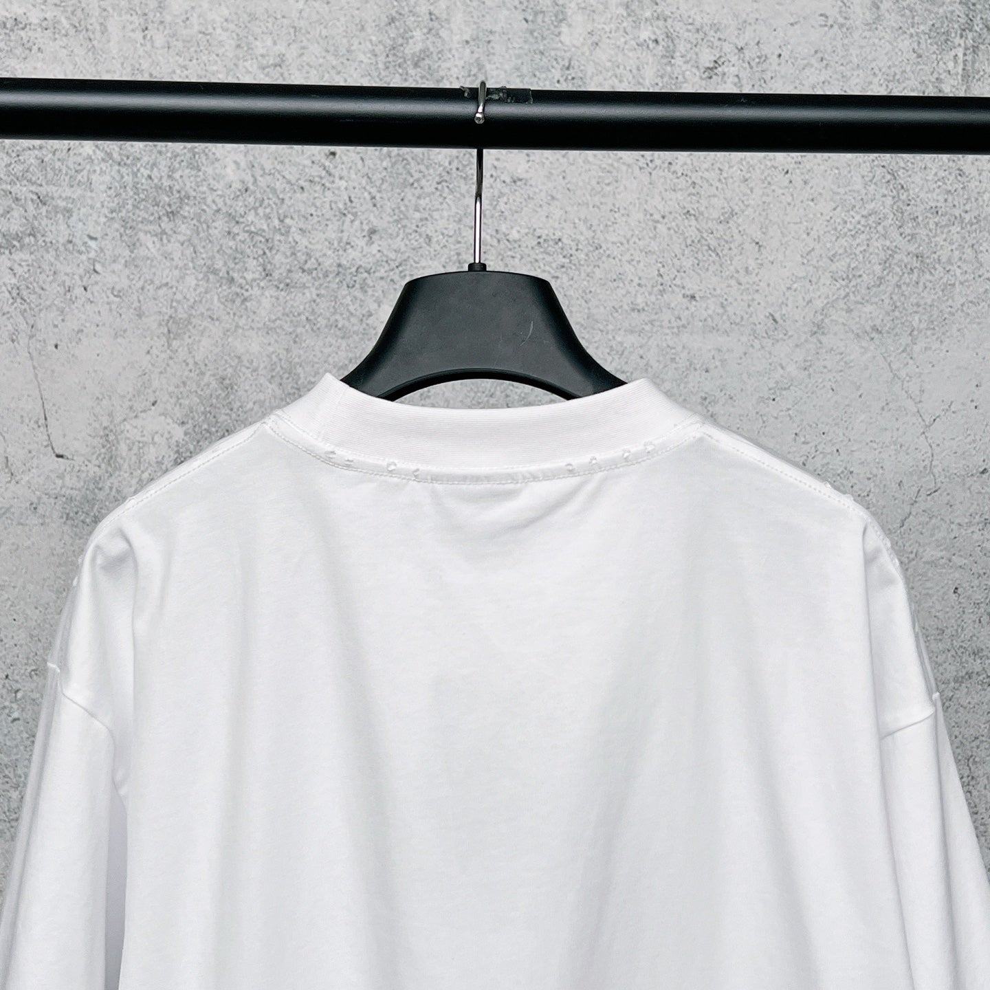 White T-shirt back view on hanger, plain rear panel