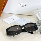 Black sunglasses with dark lenses, glossy frame, and curved cat-eye shape
