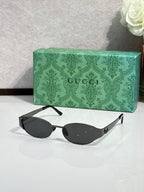 Gucci sunglasses with black lenses and black frame, oval lenses and side detail
