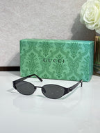 Gucci sunglasses with black lenses and black frame, oval shape and slim arms