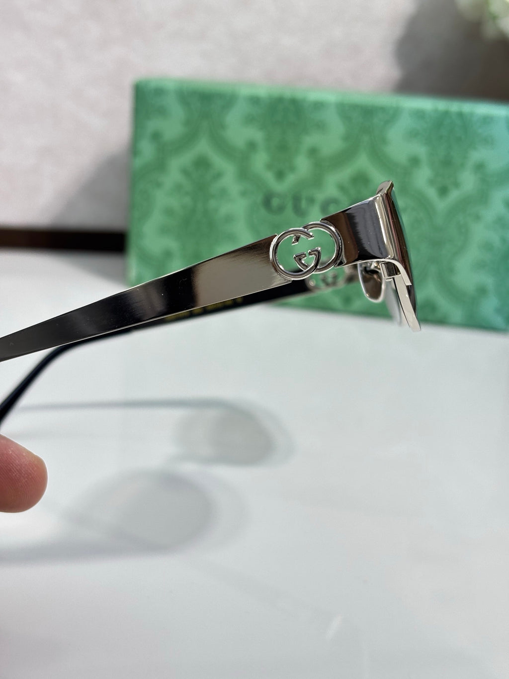 Gucci sunglasses arm detail with engraved logo badge on metal hinge