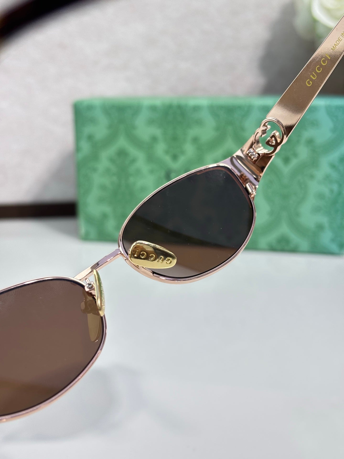 Gucci sunglasses close-up of gold-tone rim and dark tinted lens