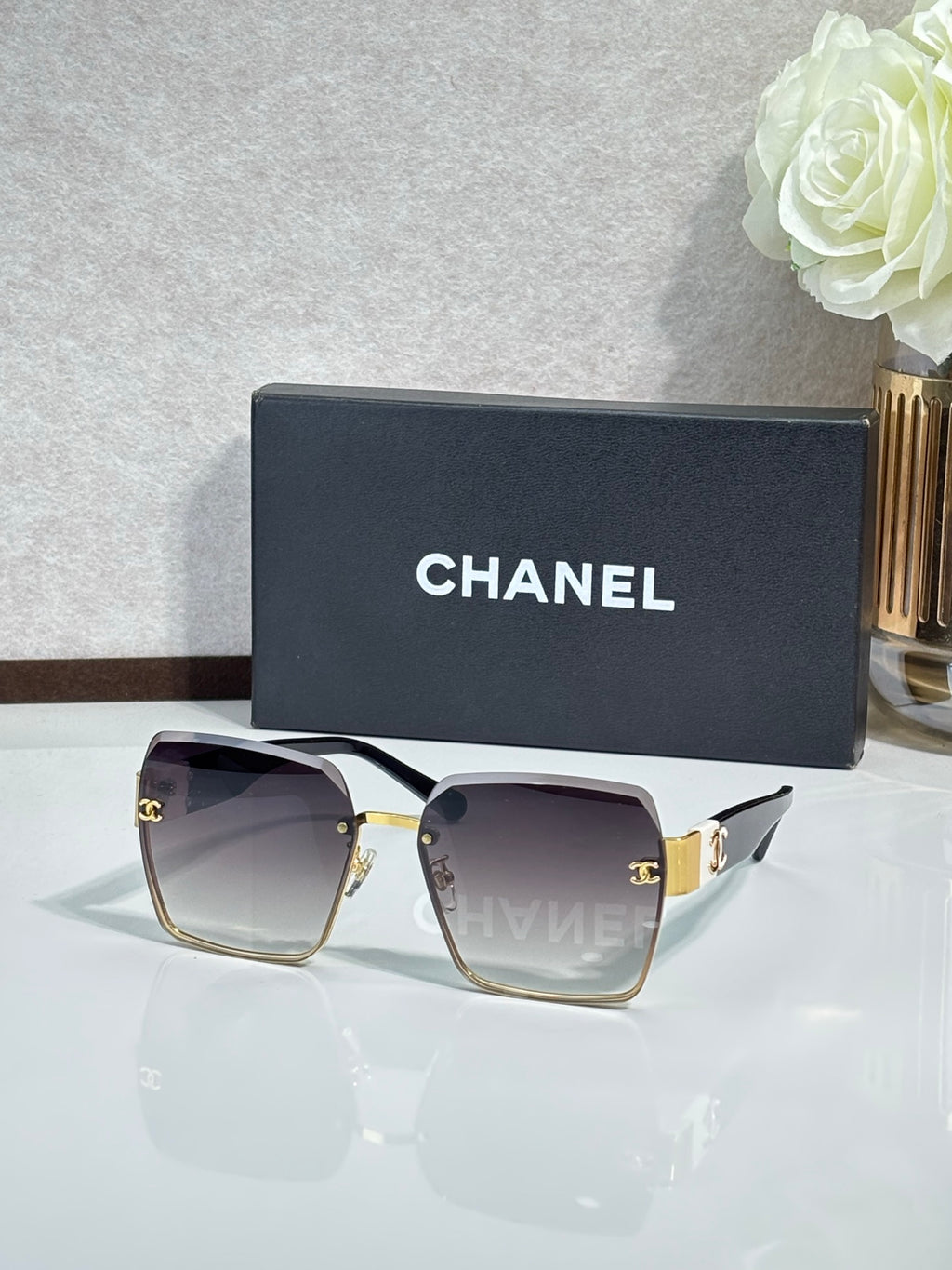 Chanel sunglasses with gold frame, dark purple gradient lenses, square shape