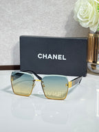 Chanel sunglasses with gold frame, teal gradient lenses, square corners