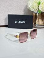 Chanel sunglasses with light pink lenses, white temples, gold hardware
