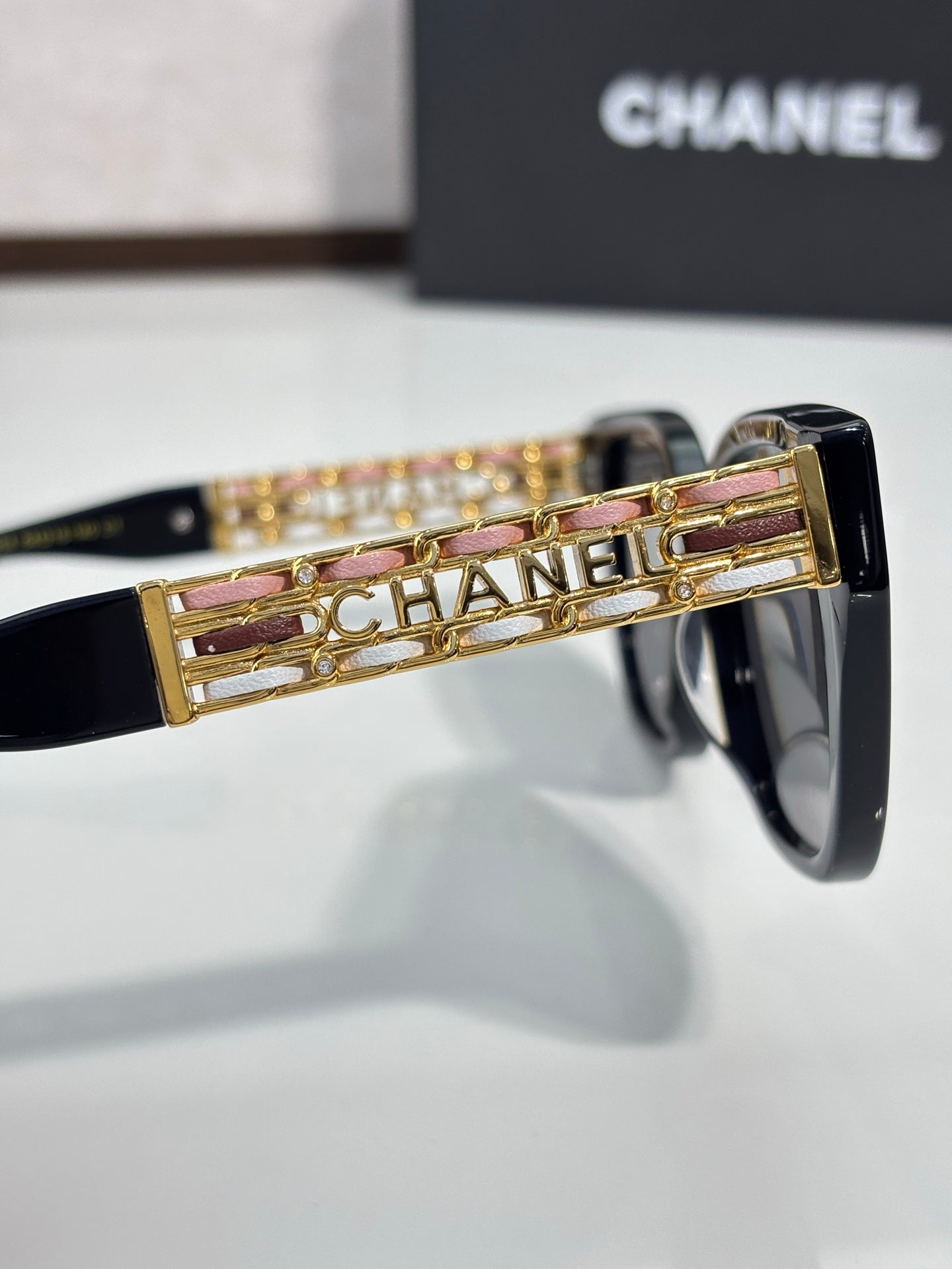 Chanel sunglasses temple detail with gold logo and pink enamel