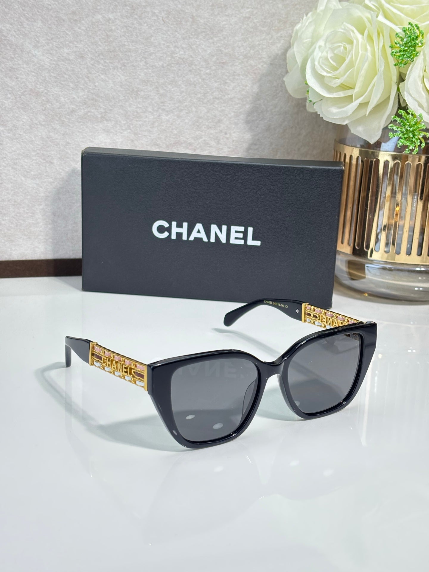 Chanel sunglasses with black frame and gold detail on temples
