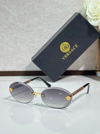 Versace sunglasses: round dark frames, clear gray lenses, gold-tone temples.