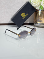 Versace sunglasses: round lenses with silver frames and gold-tone temples, side view.