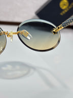 Versace sunglasses close-up: round tinted lens, gold bridge, blue-and-black temple.