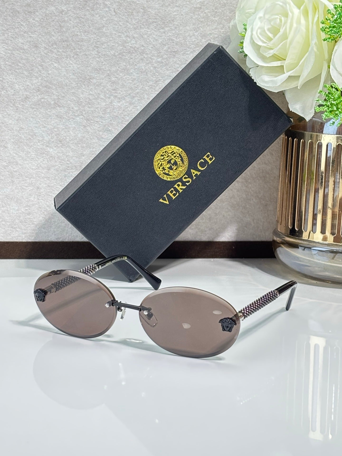 Versace sunglasses: round dark frames, gold-tone temples, tinted lenses.