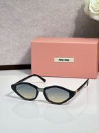 Black cat-eye sunglasses with tinted lenses and gold-tone hinge details