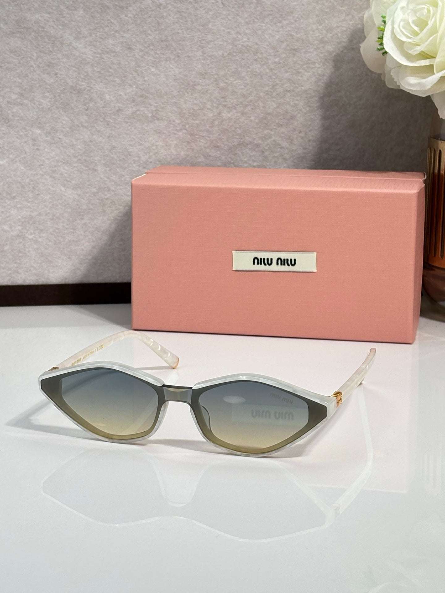 Light olive cat-eye sunglasses with tinted lenses and gold-tone temple details
