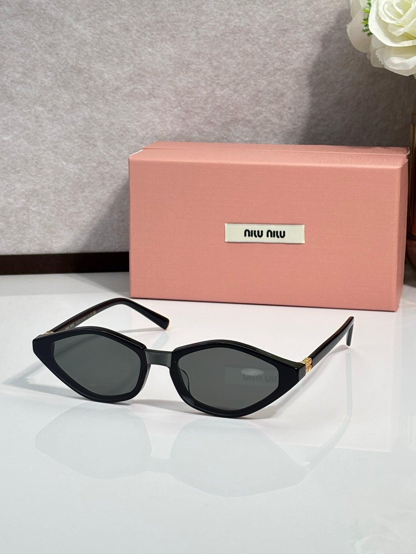 Black cat-eye sunglasses with dark lenses and gold-tone temple accents