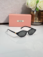 Black cat-eye sunglasses with dark lenses and gold-tone chain-style temple detail