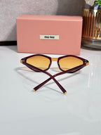 Burgundy cat-eye sunglasses with amber lenses and gold-tone temple accents