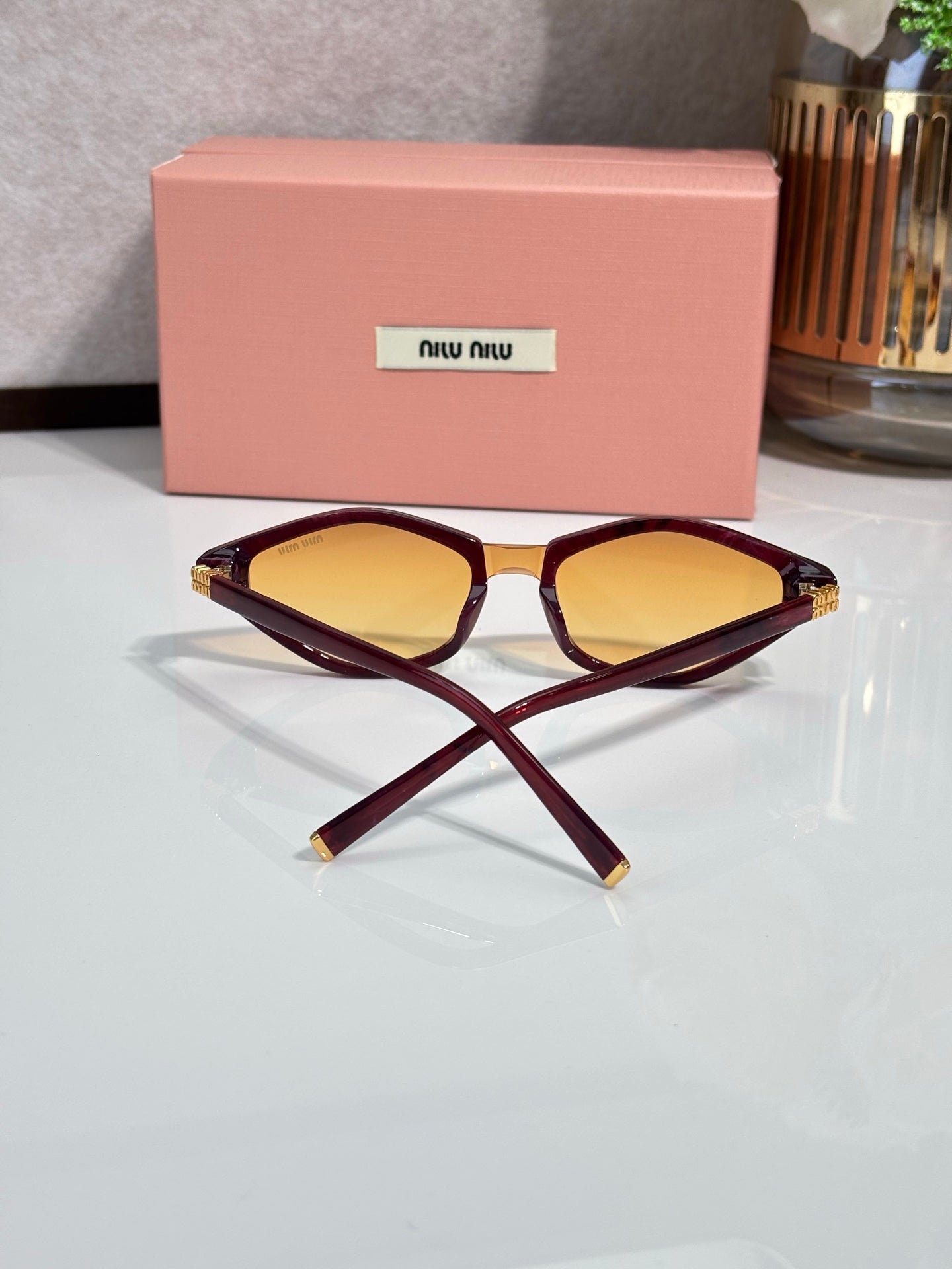 Burgundy cat-eye sunglasses with amber lenses and gold-tone temple accents