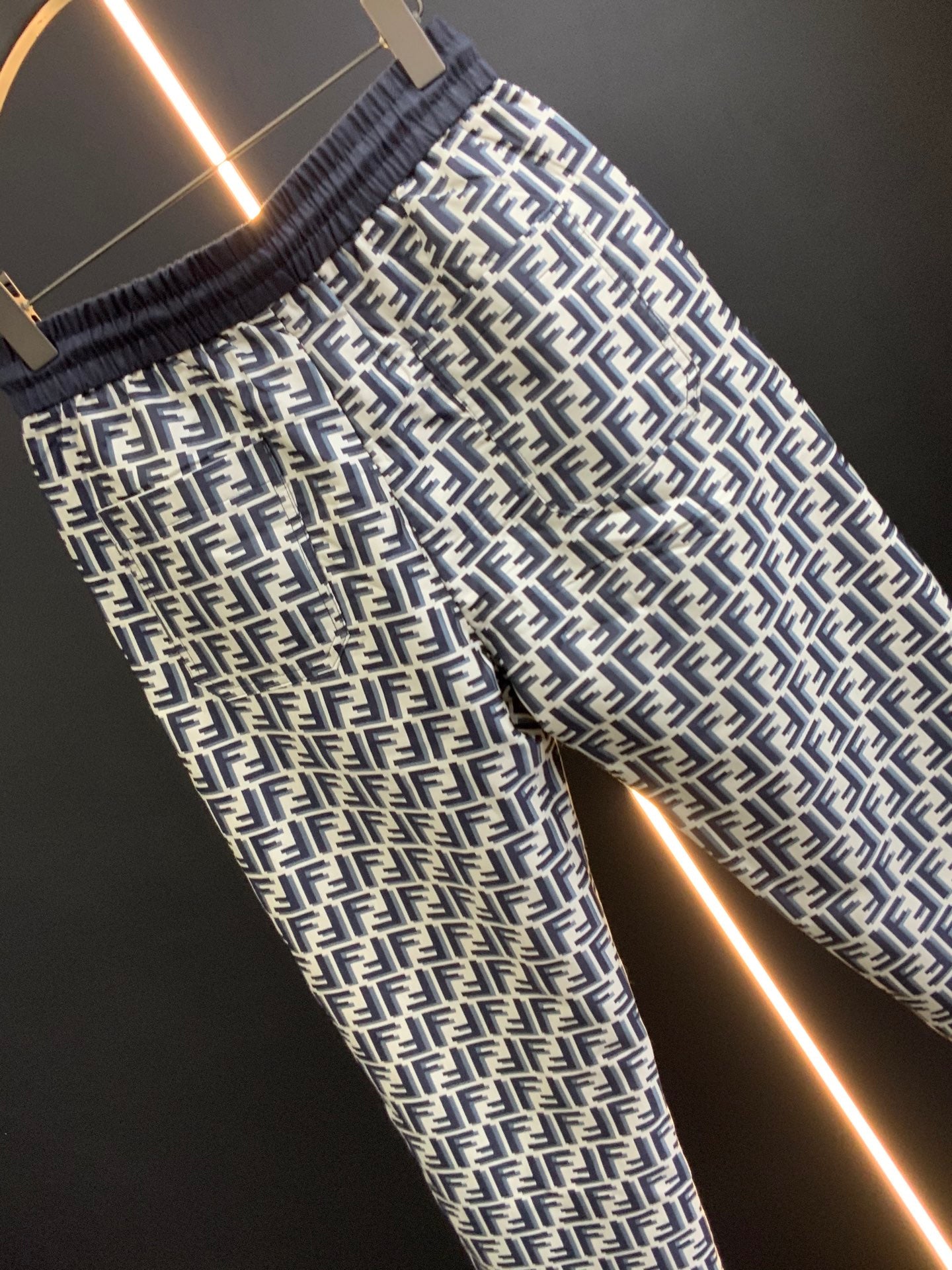 Black pants with white FF-style repeating pattern and elastic waistband, angled view
