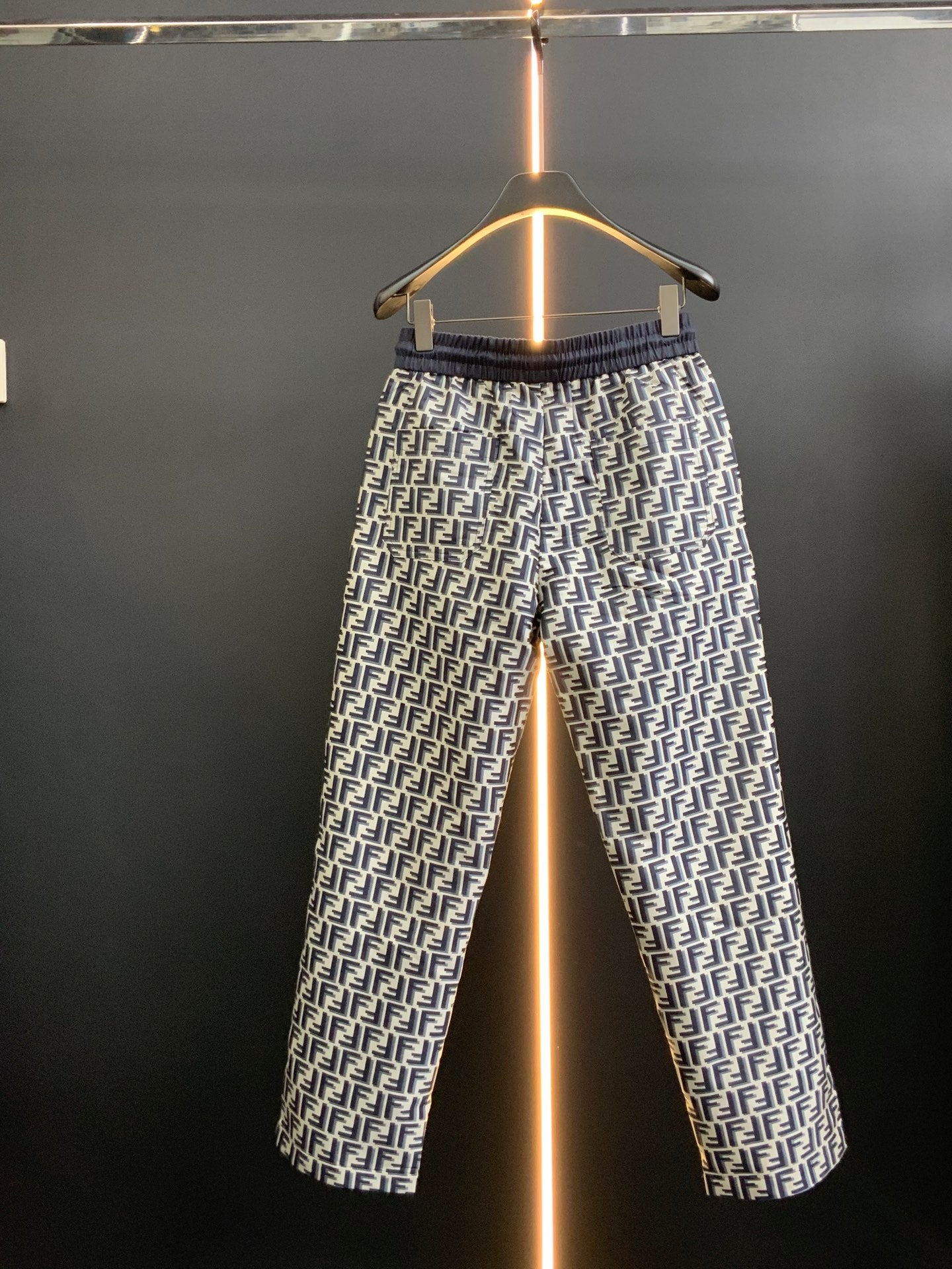 Pants in black with white FF-style repeating pattern and elastic waistband, full view