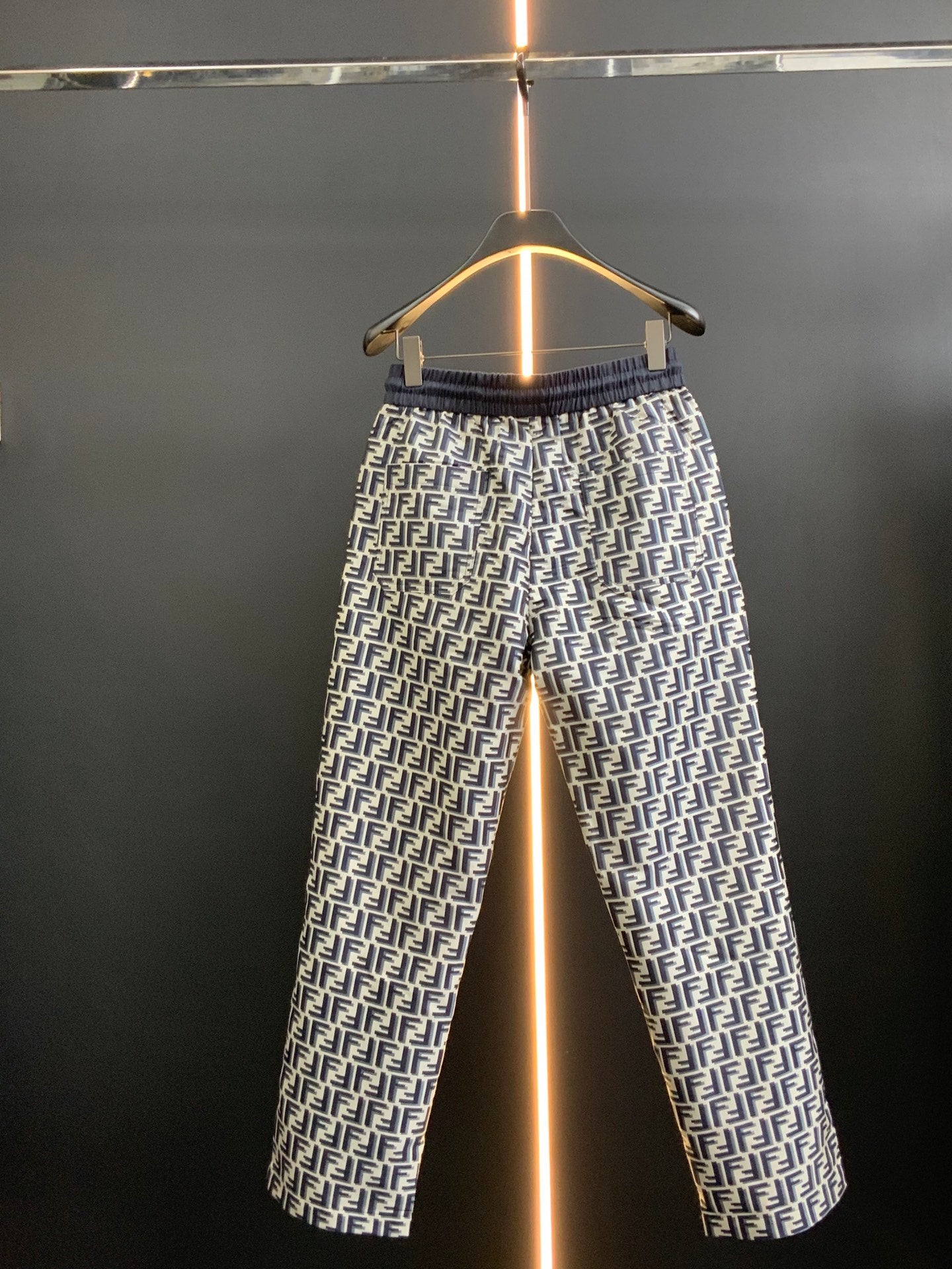 Pants in black with white FF-style repeating pattern and elastic waistband, full view