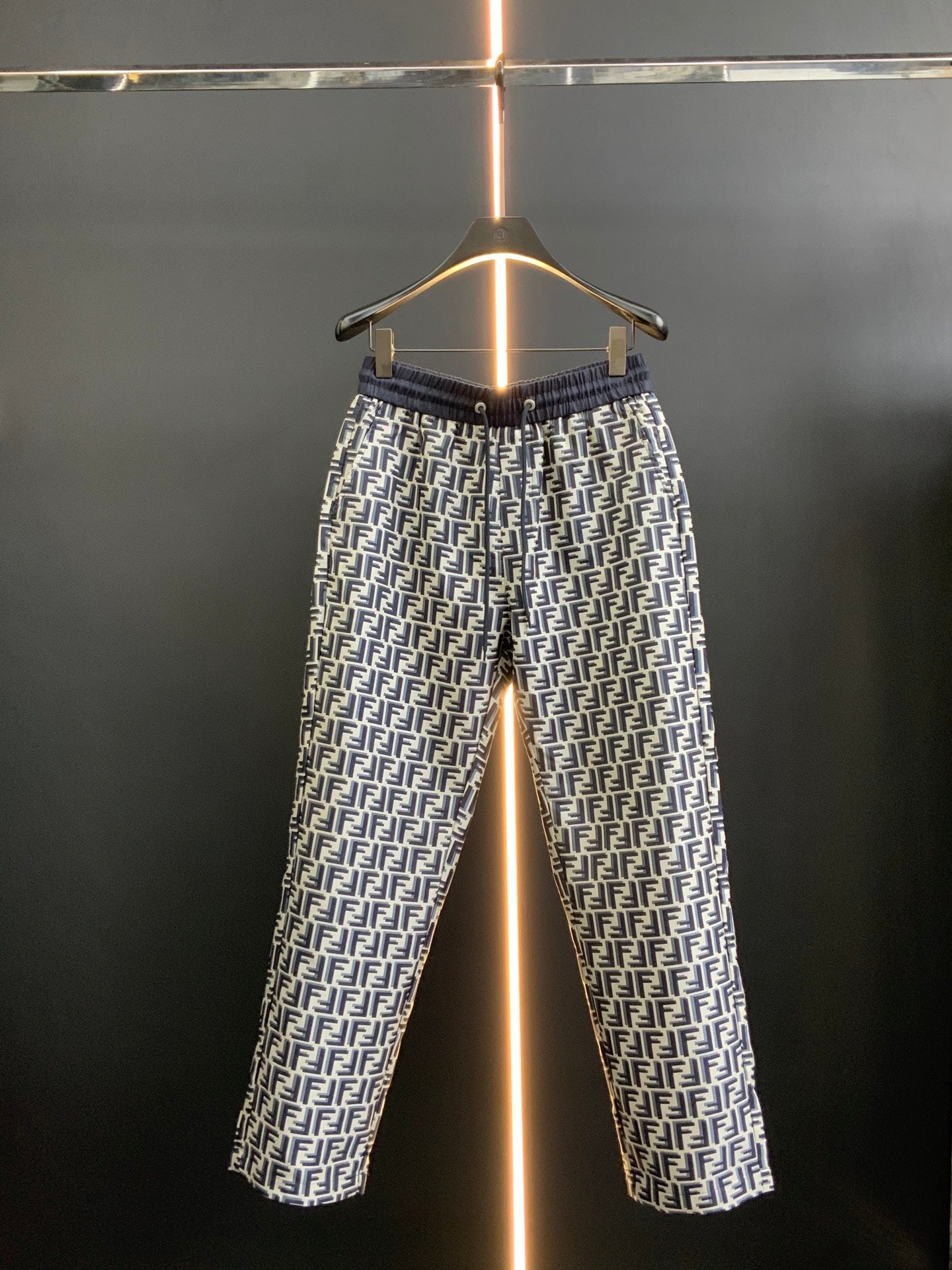 Black pants with white FF-style repeating pattern and elastic waistband, full view