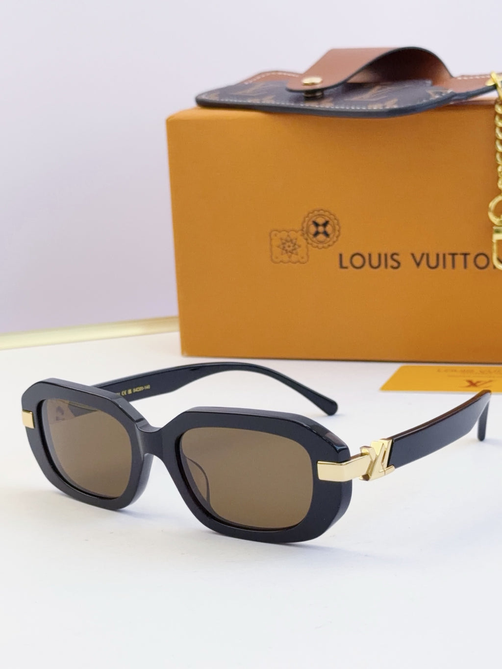 Louis Vuitton glasses, dark frames with brown-tinted lenses and gold bridge detail