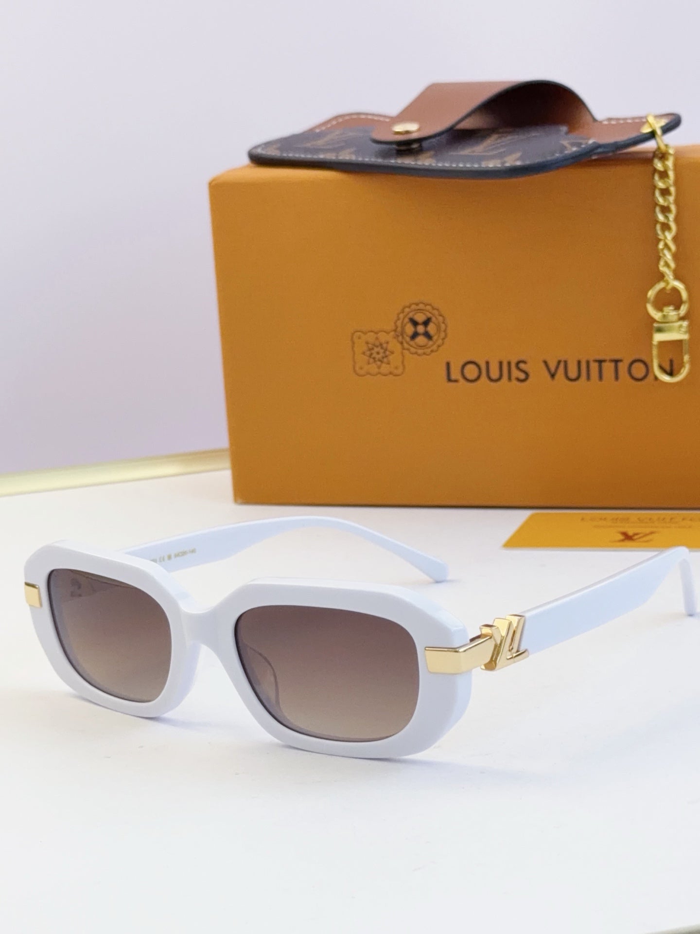 Louis Vuitton glasses, white frames with brown-tinted lenses and gold hinges