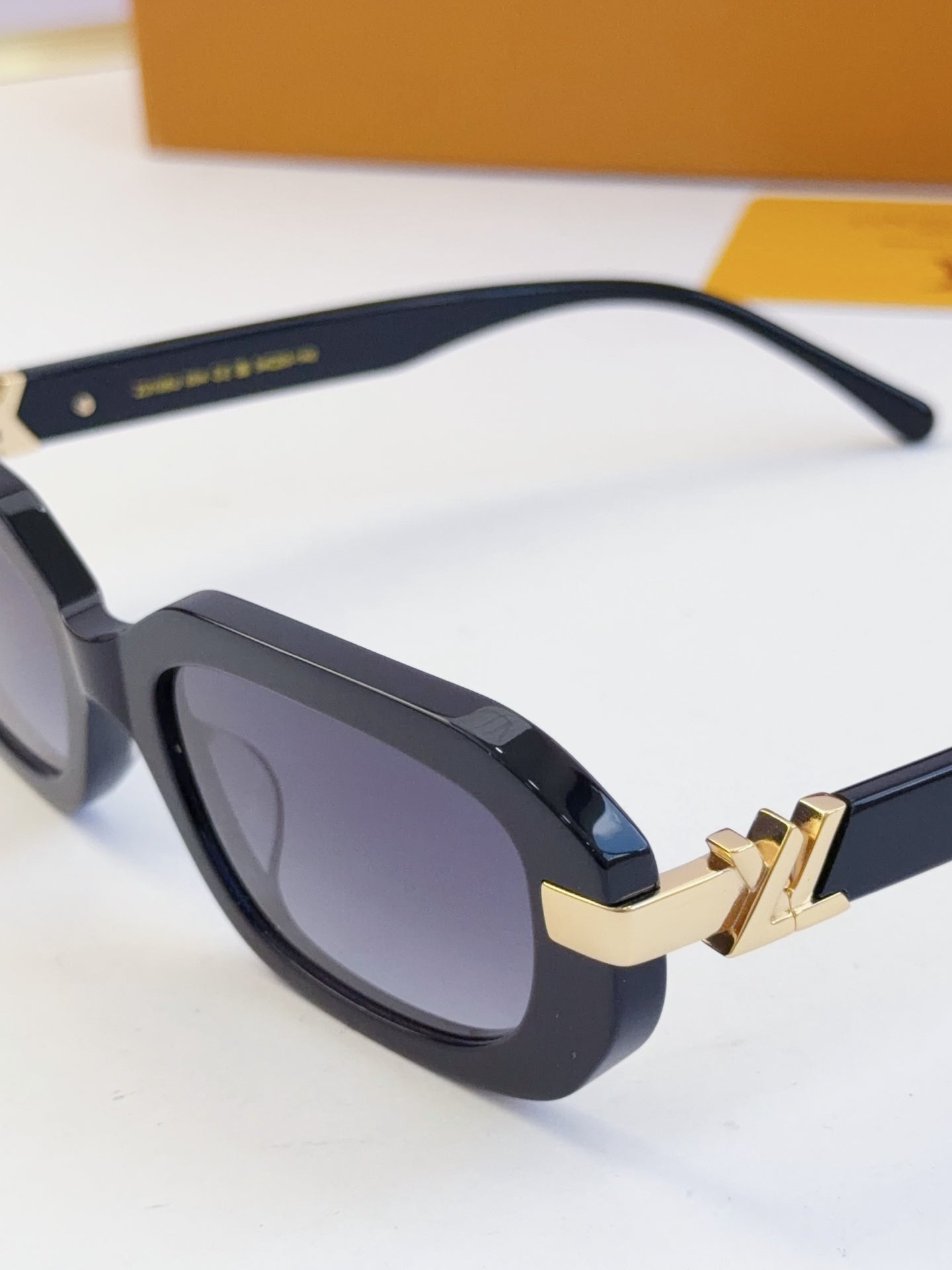 Louis Vuitton glasses with dark frames and gold bar bridge detail