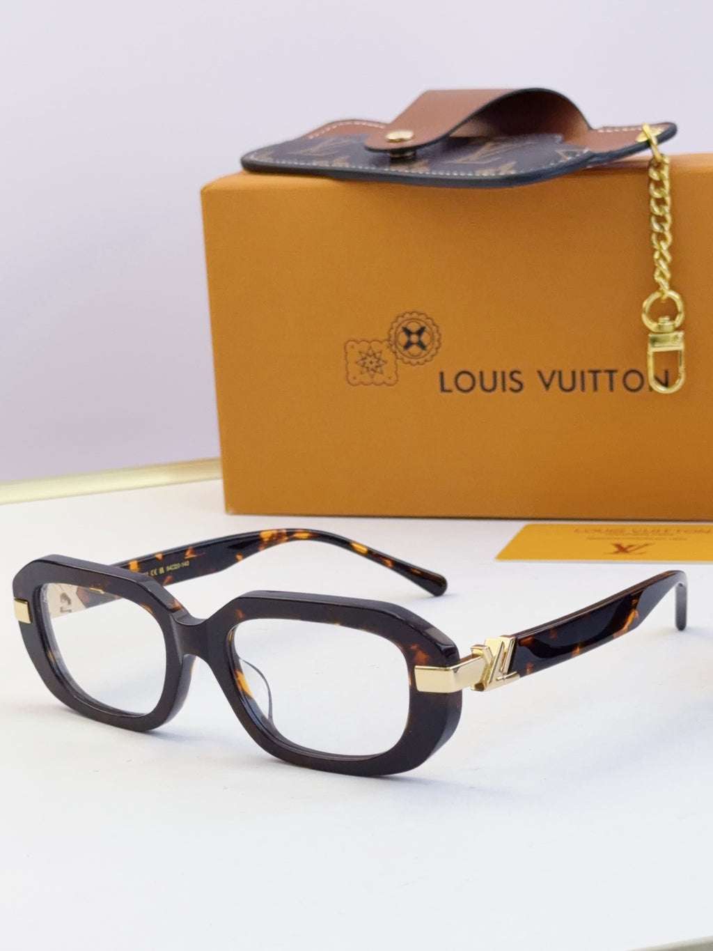 Louis Vuitton glasses with dark tortoiseshell frames and gold hinge detail