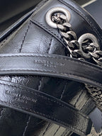 Saint Laurent leather bag detail with front panel stitching and chain hardware
