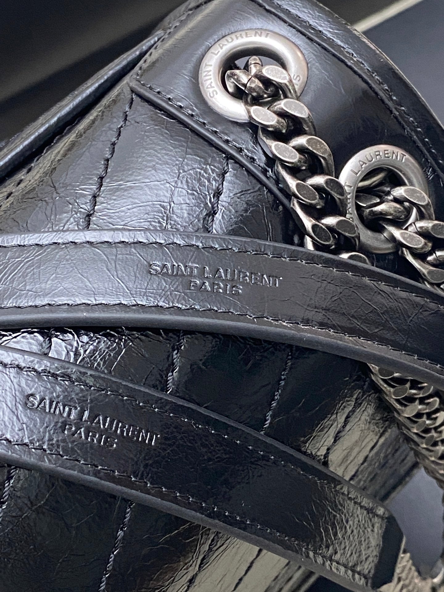 Saint Laurent leather bag detail with front panel stitching and chain hardware