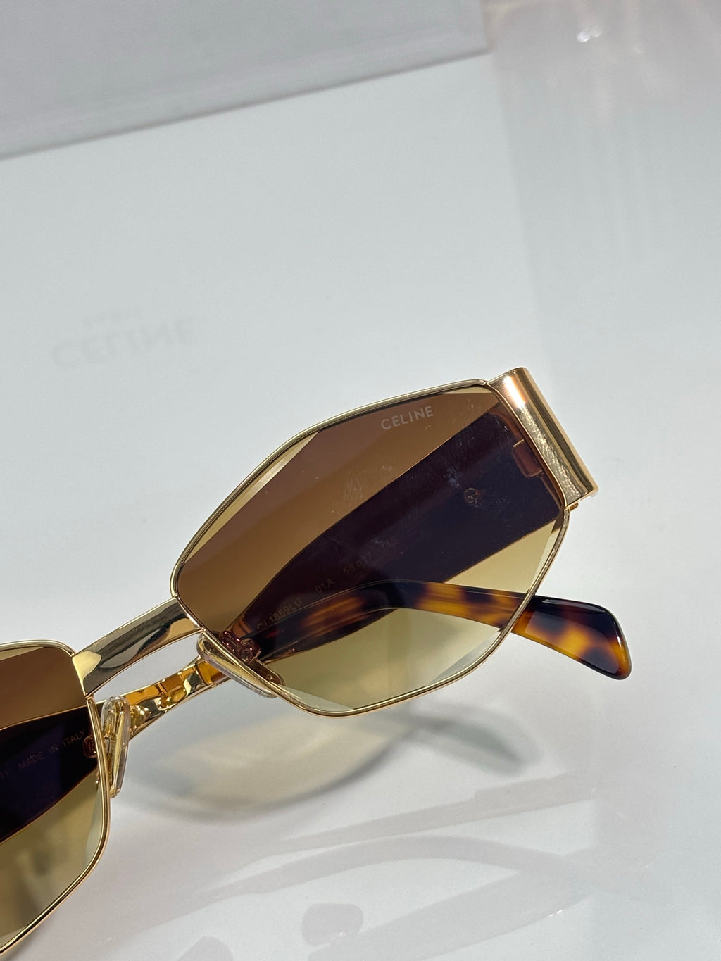 Close-up of gold sunglasses frame with tinted lenses
