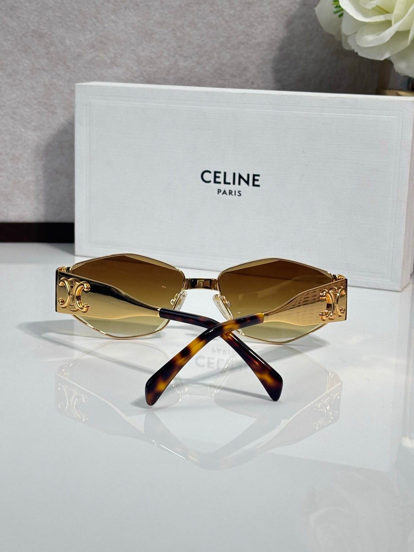 Tortoiseshell and gold sunglasses with amber lenses and curved temple arms