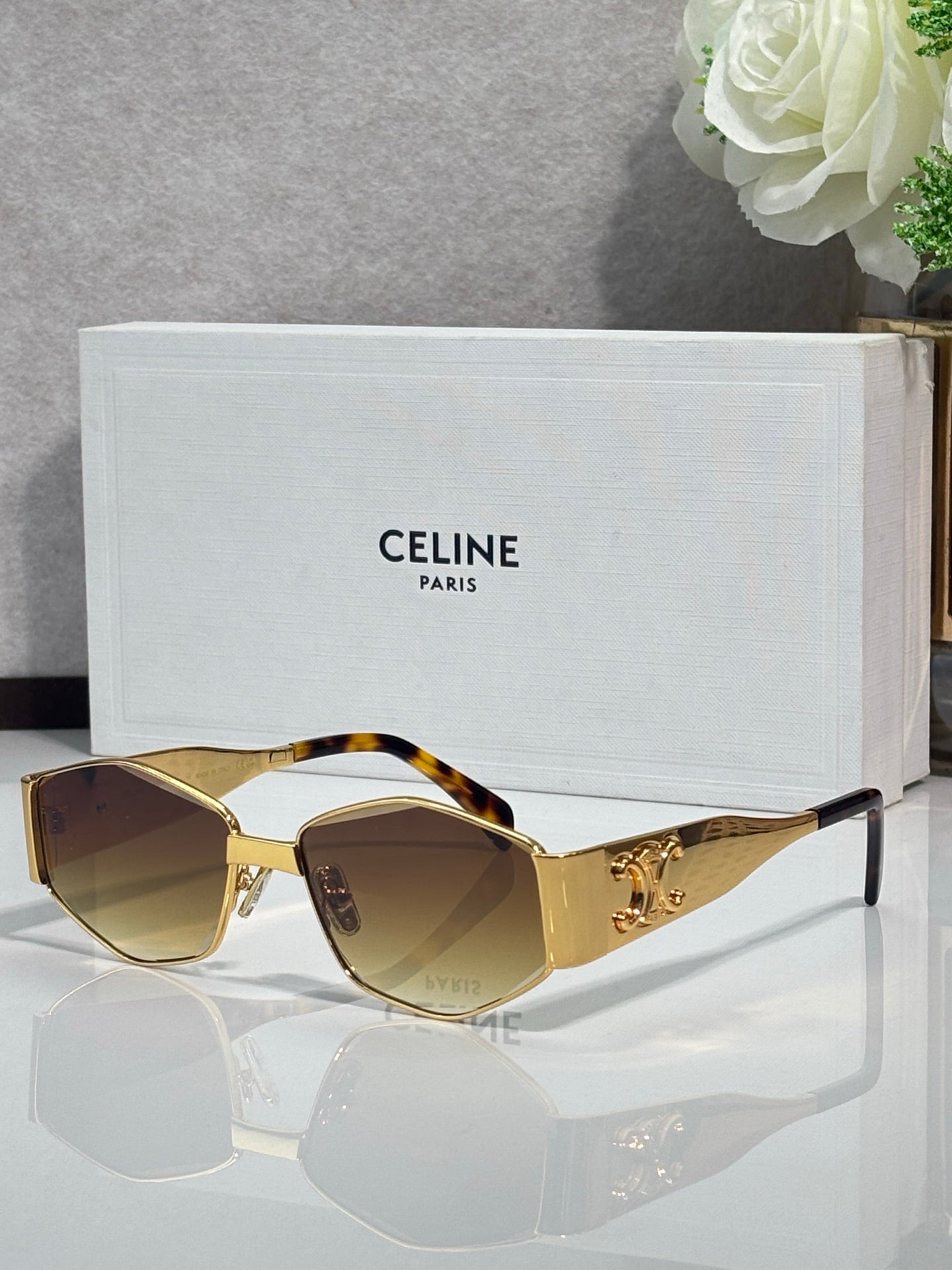 Gold and tortoiseshell sunglasses with amber lenses and ornate side frame