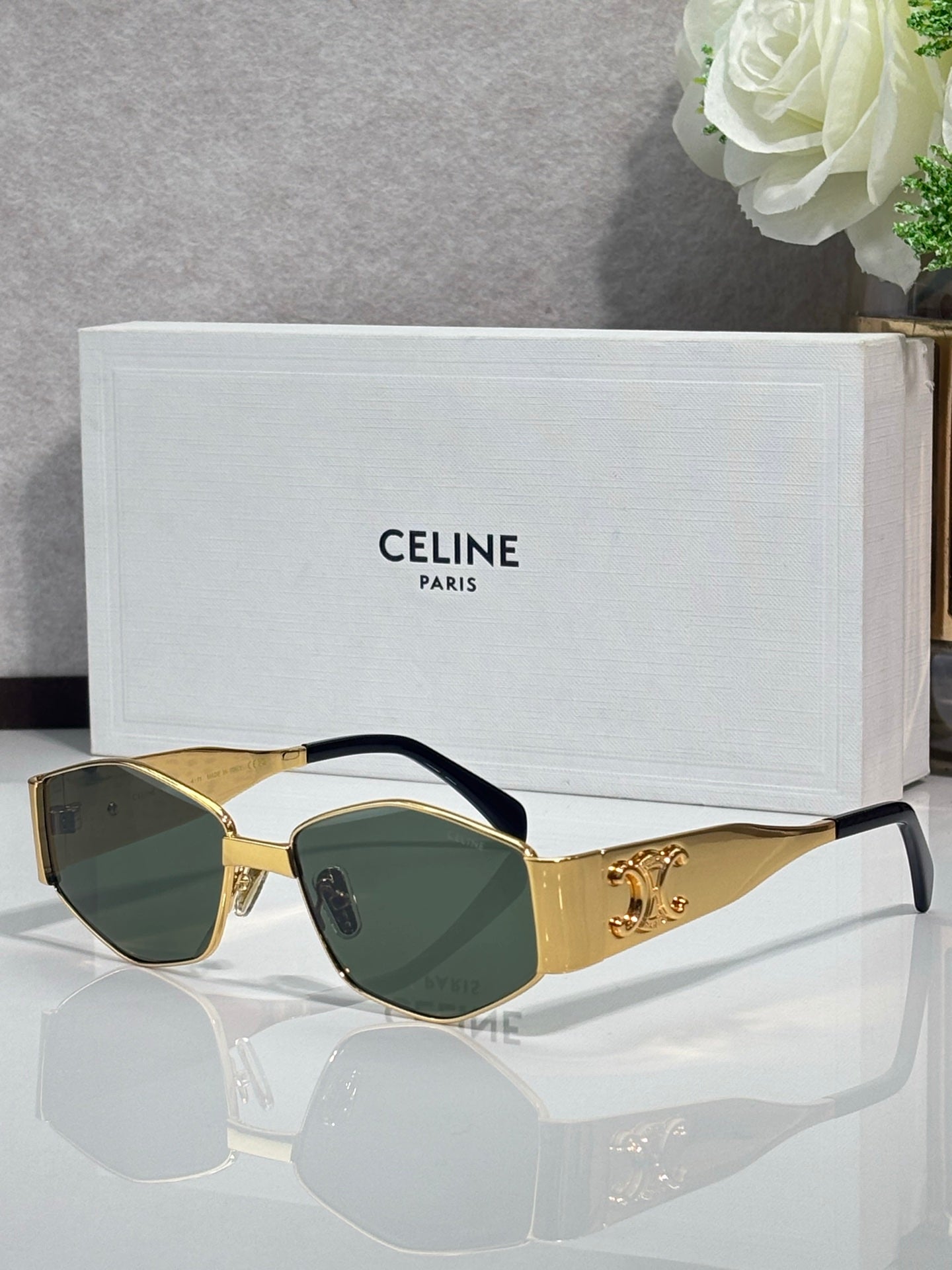 Gold sunglasses with green-tinted lenses and tortoiseshell temple arms