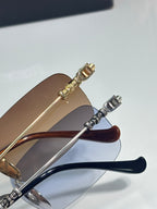Close-up of eyeglasses temples in gold and silver with blue-tinted lens edges.
